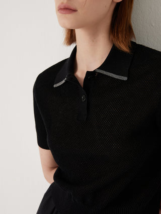 Close-up of black polo-neck knit top collar with beaded trim and button placket.