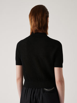 Back view of black knit polo-neck top with ribbed sleeves and fitted knit body.