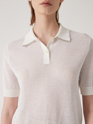 Close-up of white polo-neck knit top with beaded-trim collar and button placket.