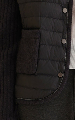Close-up of black down knit jacket lining with snap buttons on the front placket