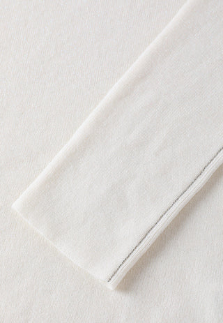White sweater sleeve cuff with subtle metallic side trim along the edge