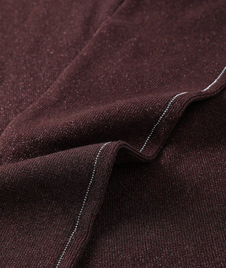 Deep burgundy fabric close-up with shimmering metallic piping
