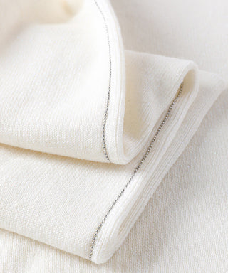 White knit sweater with silver metallic seam detail at cuff and side edge