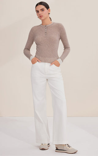 Taupe long-sleeve henley top with front buttons and rib texture worn with white pants