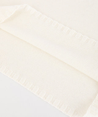 White knit top hem and cuff ribbing close-up on lightweight fabric texture