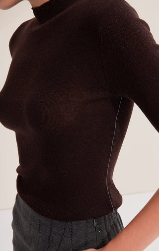 Close-up of brown high-neck knit top with half sleeves and ribbed texture
