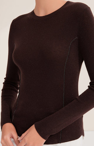 Close-up of dark brown rib knit top with beaded zipper-like seam running down