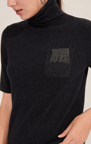 Close-up: black short-sleeve turtleneck sweater pocket with silver bead fringe detail