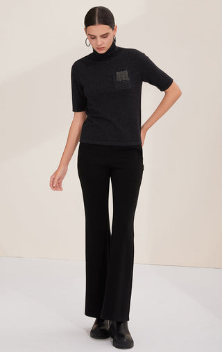 Black short-sleeve turtleneck knit sweater with bead-fringe pocket detail, front view