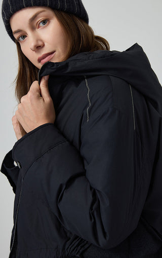 Black hooded jacket close-up of shoulders and hood lining, zipper panel visible