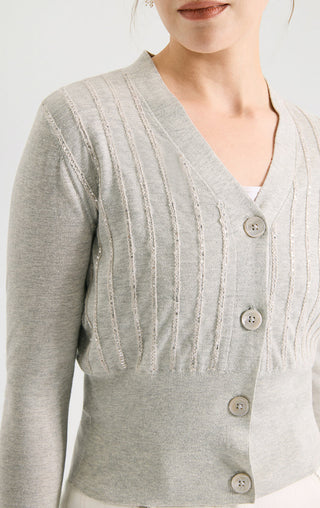 Light gray V-neck fitted short knit cardigan close-up of buttons and ribbed texture