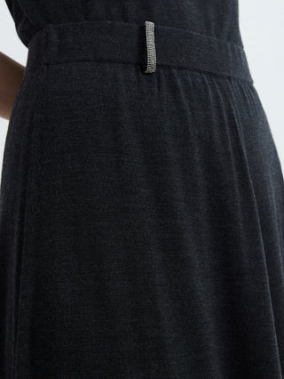 Close-up of black high-waisted knit midi skirt waistband with small metal pin detail