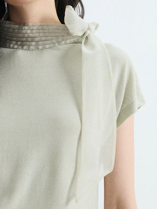 Close-up of olive green knit blouse mock neck with layered organza bow tie