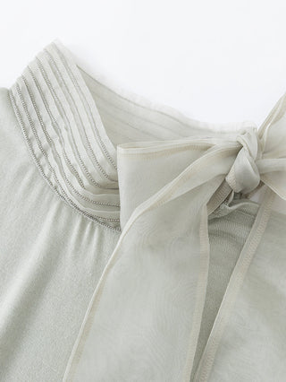 Organza bow and ribbed mock neck detail on an ivory wool-silk knit blouse