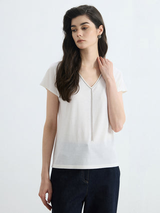White knit V-neck top, silver beaded edging and hanging tassel at center