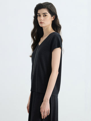 Side view of black V-neck knit top with silver bead trim; short sleeves
