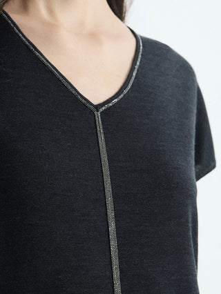Detail of black V-neck knit top: silver bead-trim edging around neckline and center line