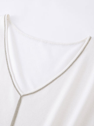 Silver beaded trim frames white wide V-neck opening on knit top
