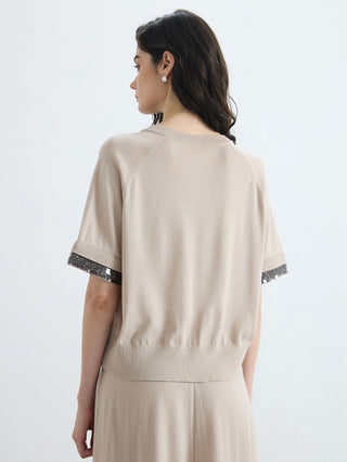Back view of beige knit top with short sleeves and silver beaded cuff detail