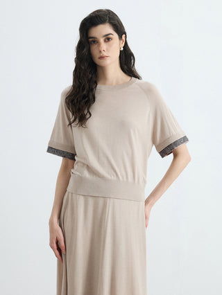 Beige knit top with silver beaded cuff trim and crew neck, relaxed fit