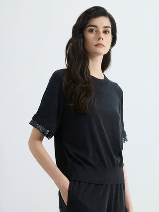 Black wool-silk knit top with silver bead cuff trim, draped fit and crew neck