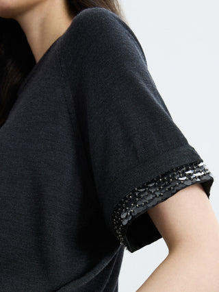Close-up: black knit sleeve cuff with silver bead and sequin trim detail