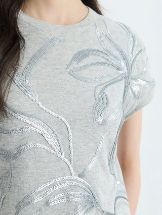 Close-up: light gray knit top with leaf embroidery in sequins and beaded trim