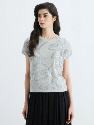 Light gray crew-neck knit top with shimmering leaf embroidery and short sleeves
