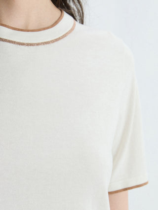 Close-up of ivory knit T-shirt neckline with brown contrast trim