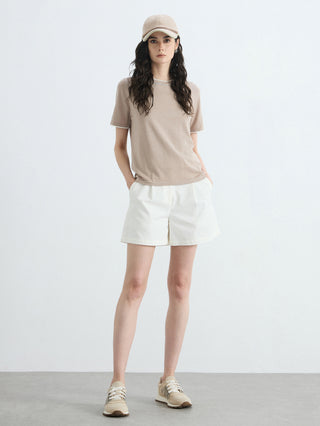 Khaki knit T-shirt worn with white bottoms; contrast trim on neck and hem
