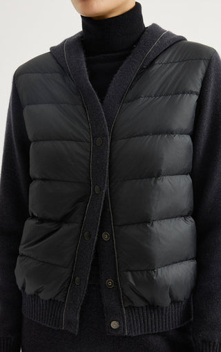Black hooded puffer jacket front detail with snap buttons and quilted padding