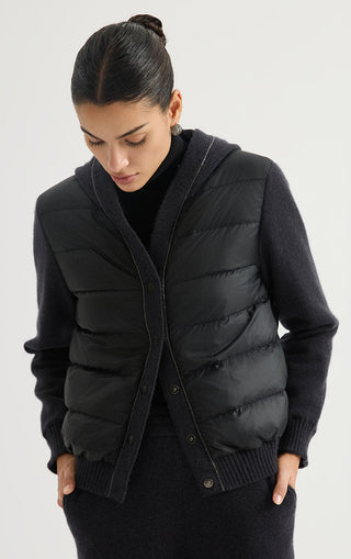 Black hooded puffer jacket with ribbed hem, snap front, and long knit cuffs