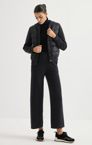 Black hooded puffer jacket worn with pants and knit cuffs, snap front closed