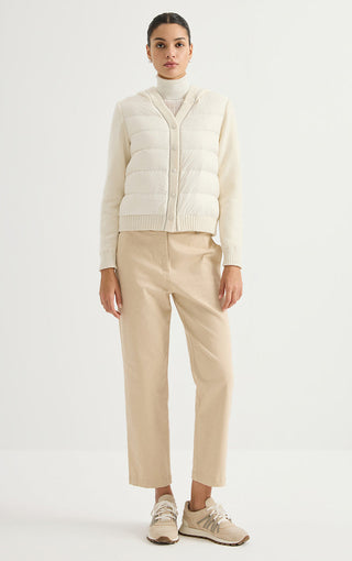 Cream hooded puffer jacket worn with pants, snap front and ribbed knit trim