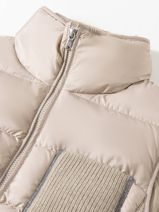 Beige puffer vest detail: front zipper and ribbed knit pocket panel