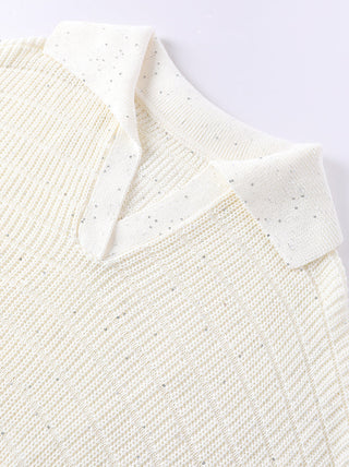Shoulder and neckline close-up of white knit pullover with fine sequins