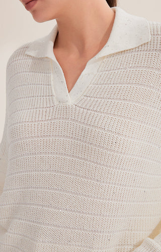 Close-up of white textured knit pullover V-neck with fine sequins detail