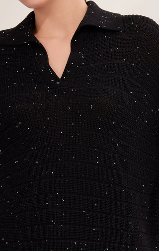 Close-up of black knit pullover with scattered fine sequins across textured ribs