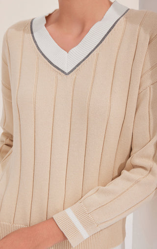 Apricot knit sweater front close-up: V-neck trim, vertical stripes, ribbed cuffs