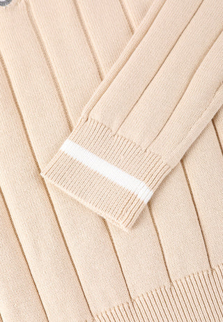 Apricot sweater sleeve cuff close-up with white rib stripe and vertical knit detailing