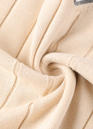 Apricot cotton V-neck sweater knit close-up with ribbed cuffs and contrast trim detail