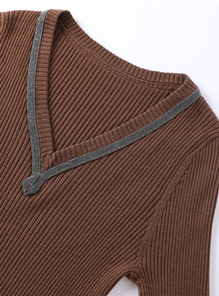 Brown ribbed wool V-neck sweater with beaded trim and ribbed cuffs at sleeve opening.