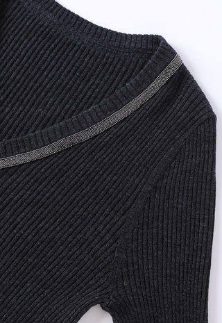 Black ribbed wool sweater with beaded trim accent and curved elbow seam detail.