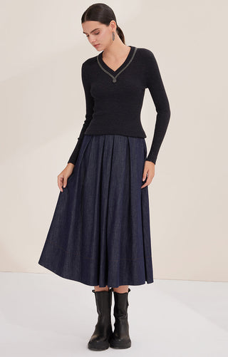 Black ribbed wool V-neck sweater with beaded trim, worn with a pleated midi skirt