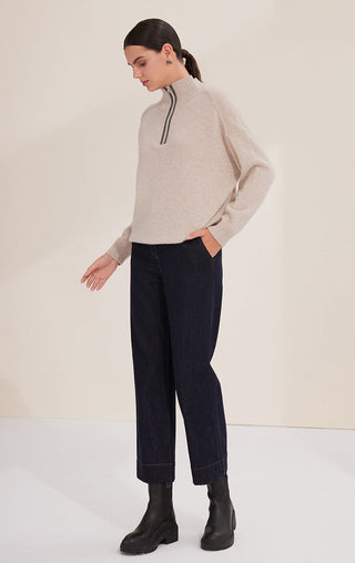 Camel wool half-zip sweater worn with dark trousers; long sleeves and ribbed cuffs