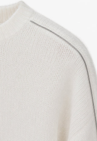 Cream knit sweater shoulder and neckline with subtle sparkly trim
