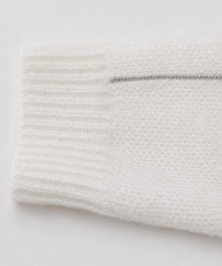 Cream knit sweater sleeve cuff detail with ribbed texture and subtle sheen