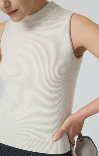 Close-up beige mock neck of cashmere tank with metal trim piping