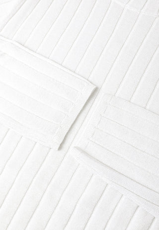 White ribbed turtleneck sweater with stitched panels and raised knit stripes.