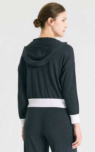 Back view of graphite gray hooded knit cardigan with white waist trim and drawstring hood